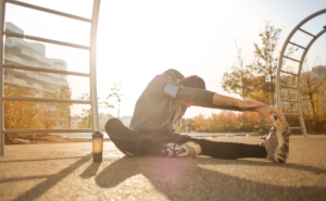 Hombre deportista haciendo estiramientos y tomando cbd para prevenir y tratar lesiones